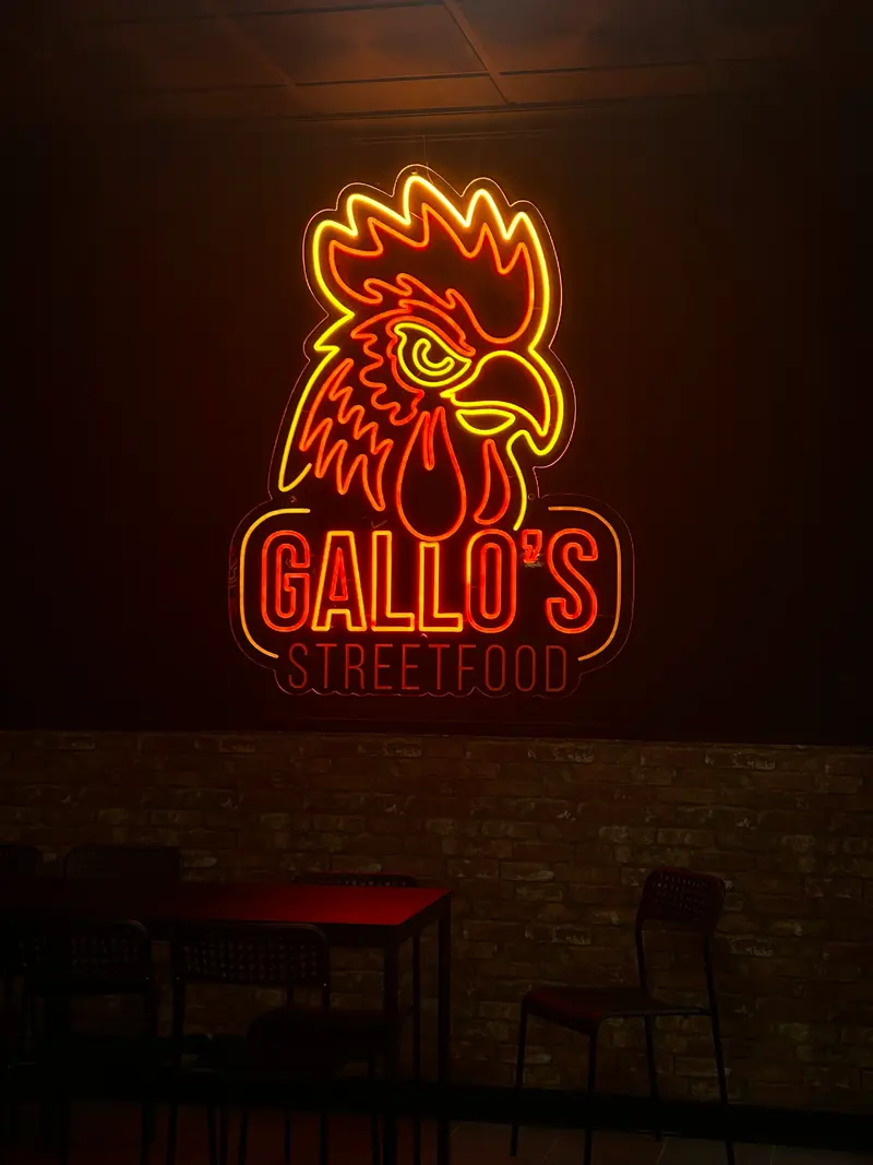 El rótulo de neón del gallo encendido en la pared del local